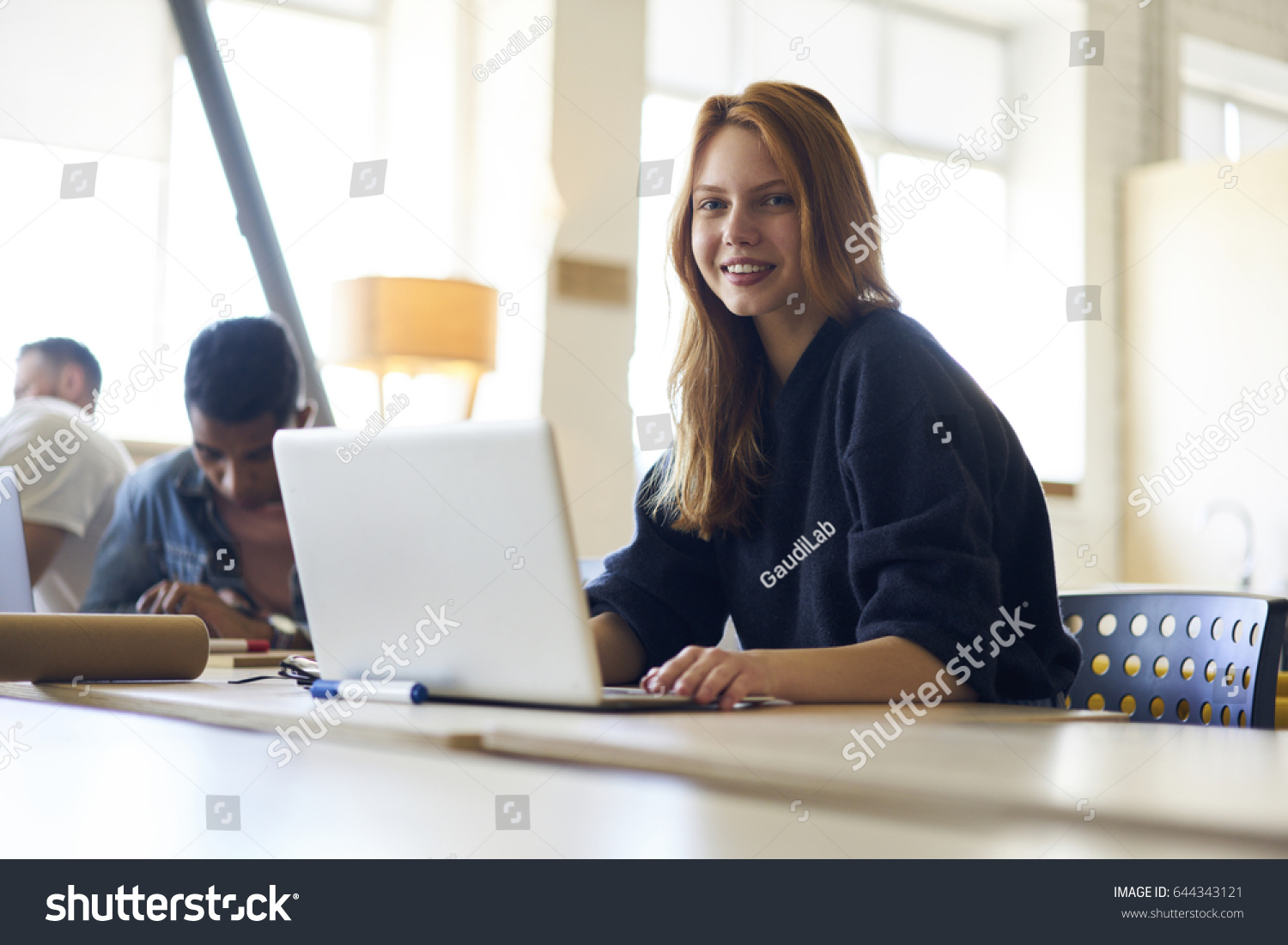 stock-photo-portrait-of-charming-young-female-student-of-university-sitting-in-modern-library-while-making-644343121.jpg