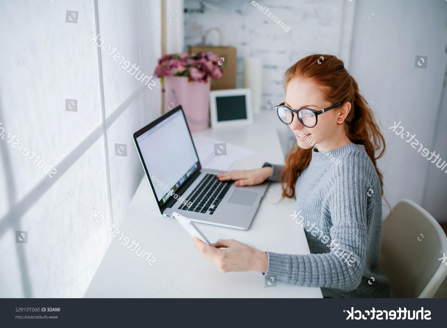 stock-photo-young-beautiful-woman-with-red-hair-wearing-glasses-working-in-the-office-uses-a-laptop-and-560751952.jpg